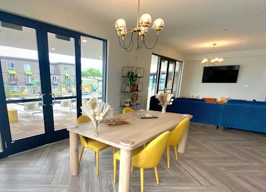 a dining area with a wooden table and yellow chairs