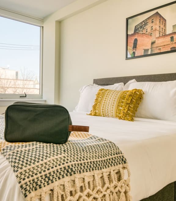a bedroom with a large bed and three windows