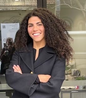 a woman standing in front of a door with her arms crossed