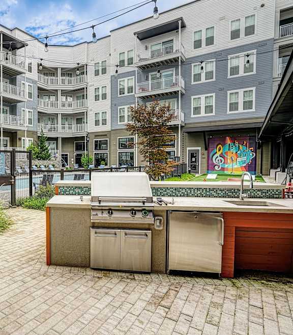 a patio with blue couches and a coffee table at Lyric at Norton Commons Apartments, Prospect, Kentucky