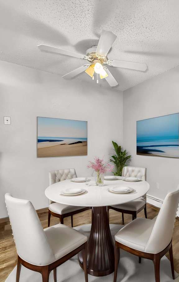 a dining room with a table and chairs and a clock on the wall at Creekstone Falls, Sioux Falls, SD