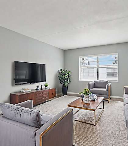 A living room with grey couches and a television.