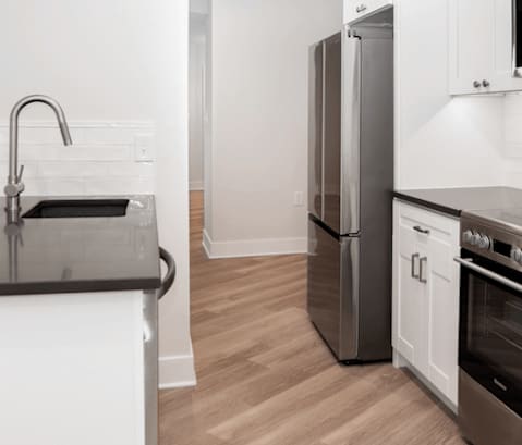 a kitchen with white cabinets and stainless steel appliances