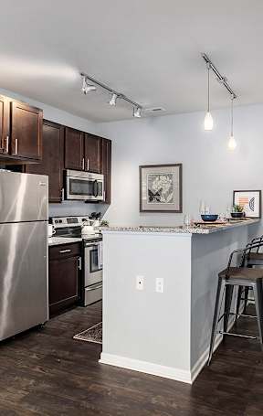 an open kitchen with a granite counter top and stools