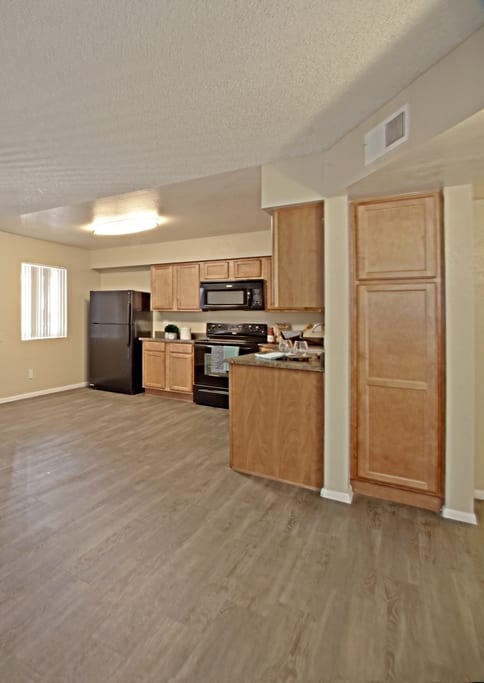 a large living room with a kitchen in the background