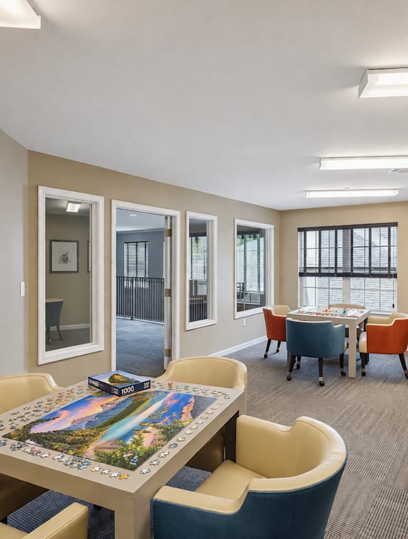 A room with tables and chairs and pictures on the wall.
