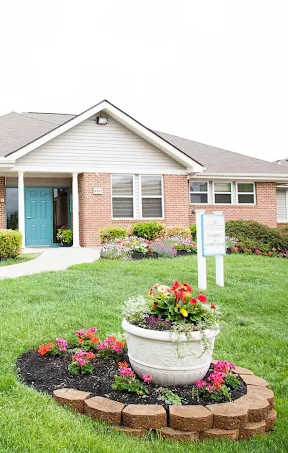 A house with a blue door and a flower pot in front.