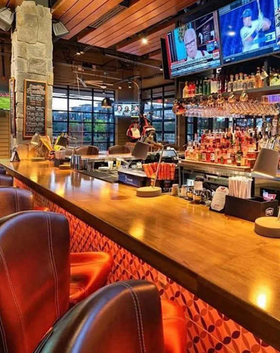 A restaurant with wooden chairs and tables set for dining.