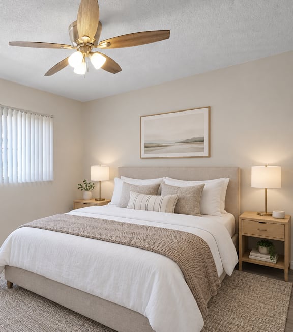 A bedroom with a large bed and a ceiling fan.