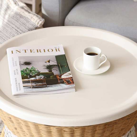 A magazine with the title Interior is on a table with a cup of coffee.