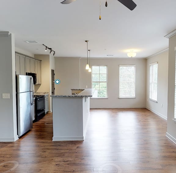 an empty kitchen and living room with wood floors and white walls at Midtown Row, Alabama, 36106