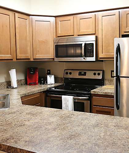 a kitchen with black cabinets and stainless steel appliances