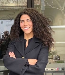 a woman standing in front of a door with her arms crossed