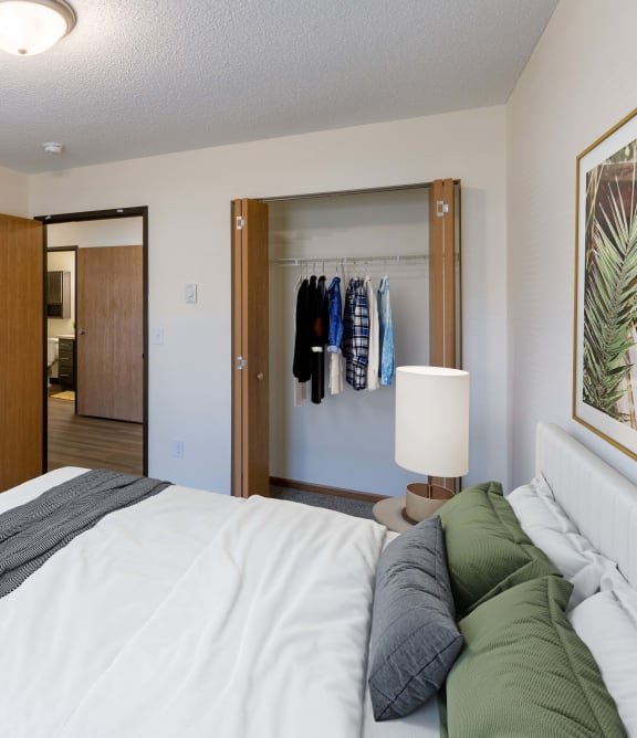 a bedroom with a bed and a dresser and a closet