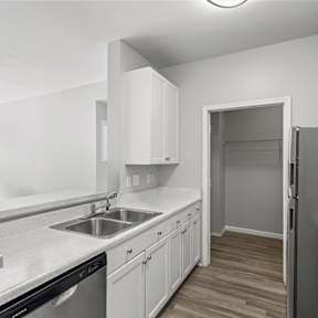 A kitchen with a white counter and a brown chair.