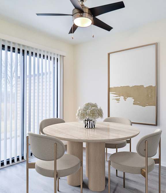 A dining room with a round table and chairs.