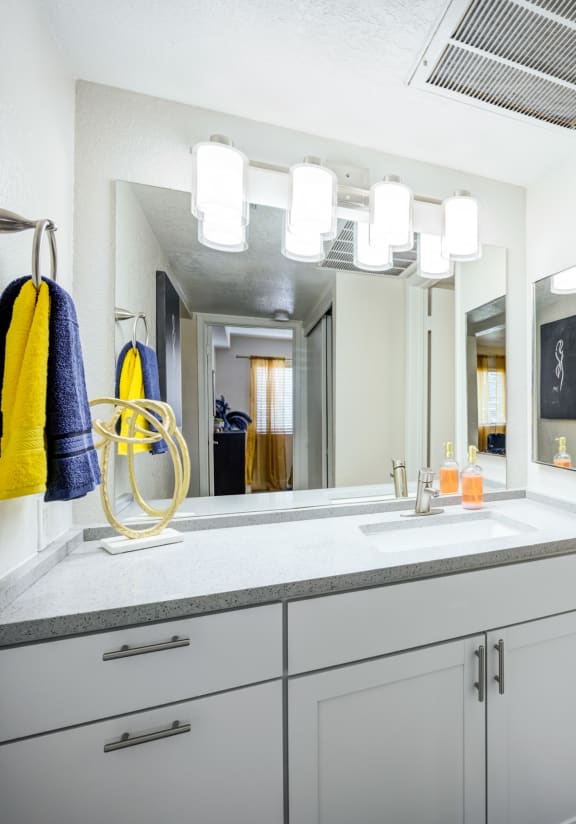 a bathroom with white cabinets and a yellow shower curtain