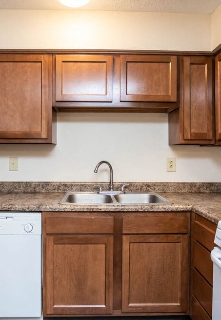 a kitchen with wood cabinets and white appliances and a sink