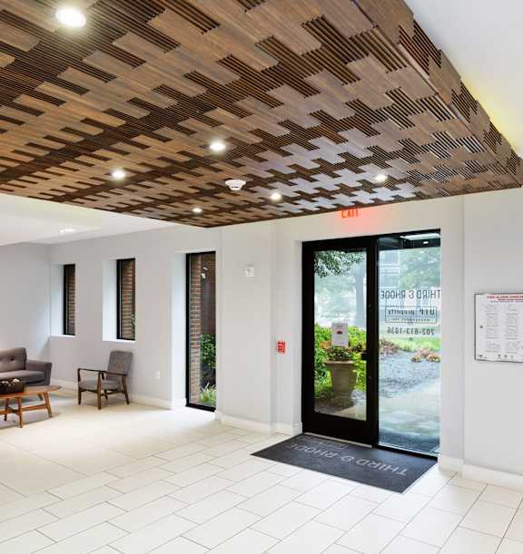 a lobby with a couch and chairs and a door that leads to a courtyard