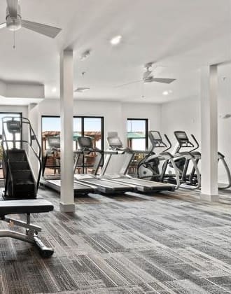 a gym with a bunch of weights and a chair  at Vue at Westchester Commons, Midlothian, 23113