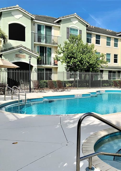 a swimming pool with an apartment building in the background at Mirabella Apartments, Princeton, FL