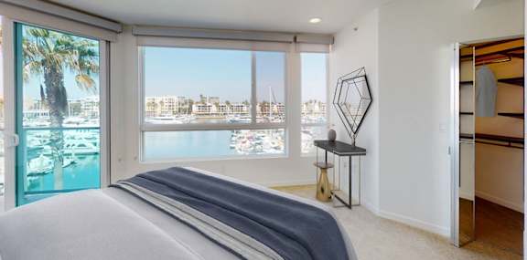 A bedroom with a large bed and a view of the city. at Esprit Apartments, California