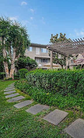 A well-maintained garden with a stone pathway leading to a building.
