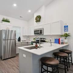 A modern kitchen with a refrigerator, sink, and countertop.