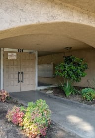 the front door of a building with a flower garden in front of it the front door of a building with a flower garden in front of it