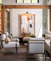 A living room with a white couch and a chair with a yellow pillow.