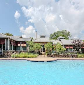 A swimming pool in front of a house with a sign on the wall.
