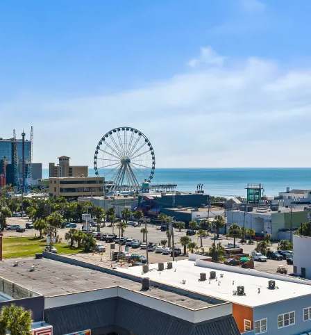 A cityscape with a large Ferris wheel in the background.