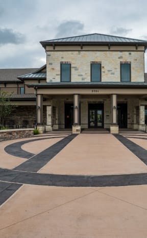 the front entrance of a large building with a circular walkway