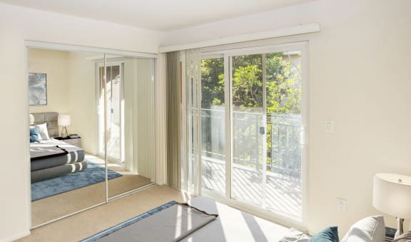 a bedroom with a bed and sliding glass doors  at Dronfield Astoria Apartments ,Sylmar, California