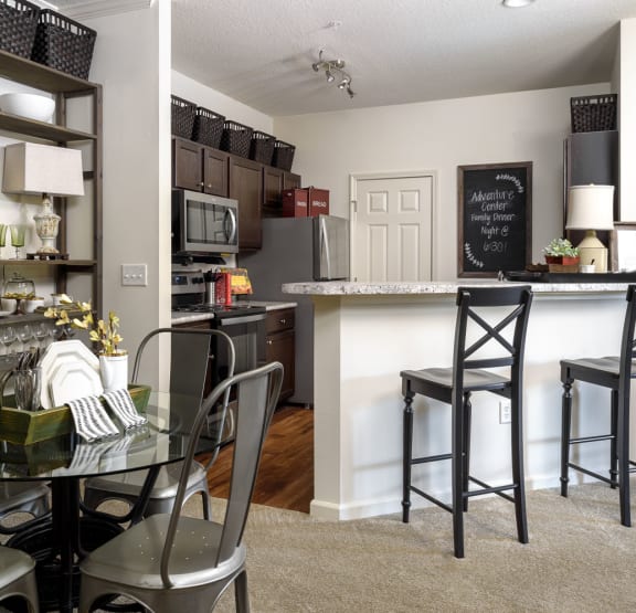 a dining room and kitchen area with a table and chairs