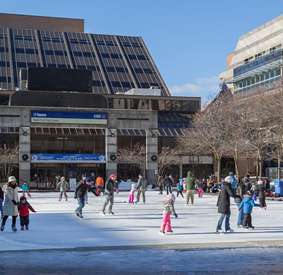 people skating on a rink in front of a building