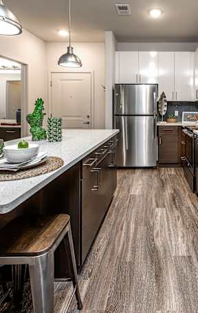 A modern kitchen with a wooden floor and stainless steel appliances.