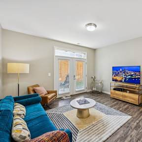 A living room with a blue couch and a television.