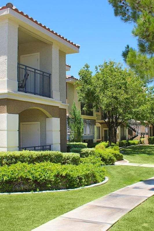 A building with a balcony and a green lawn in front at Avalon at Seven Hills Apartments, Nevada
