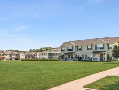 Grassy area with apartment buildings in the background.