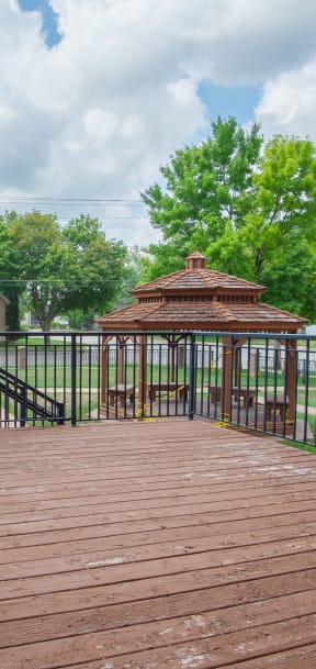 a deck with a gazebo on the side of a building
