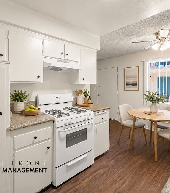 A kitchen with white appliances and wooden floors.