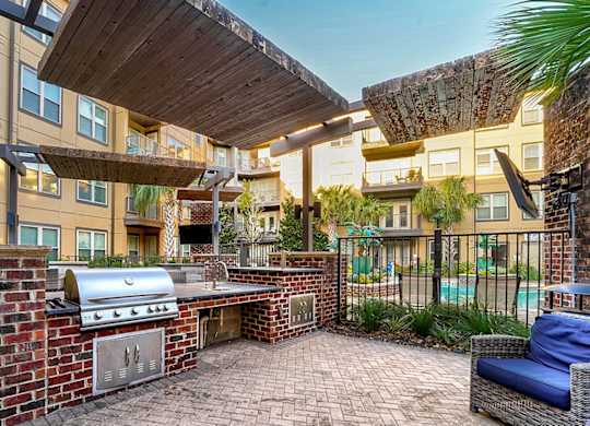 A patio with a grill and seating area.