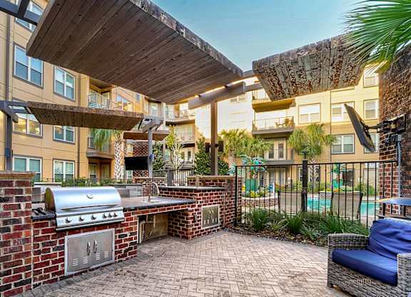 A patio with a grill and seating area.