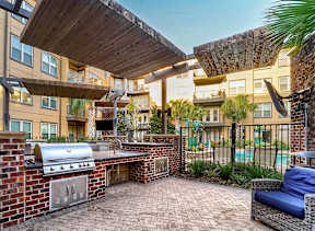A patio with a grill and seating area.