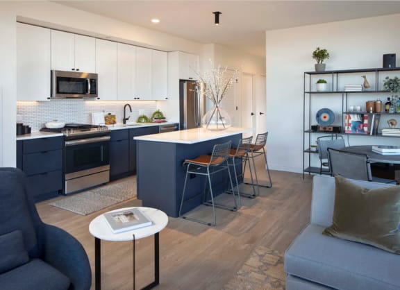 Spacious Kitchen and Living Room Area with Plank Flooring and Sleek Cabinetry at North&#x2B;Vine in Chicago, IL
