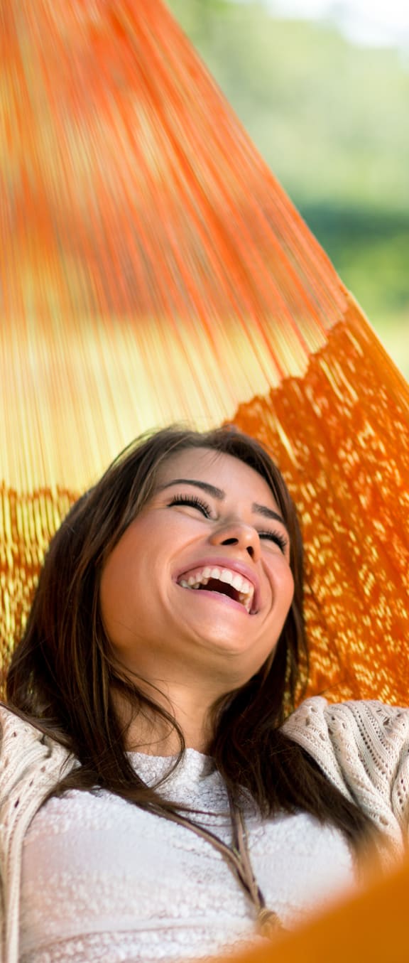 a woman laying in a hammock with her eyes closed
