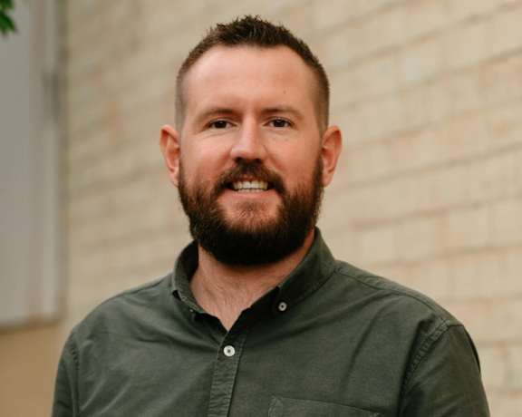 A woman with a black turtleneck and a plaid jacket.