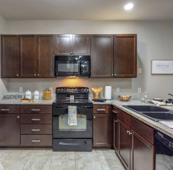 a kitchen with dark wood cabinets and stainless steel appliances