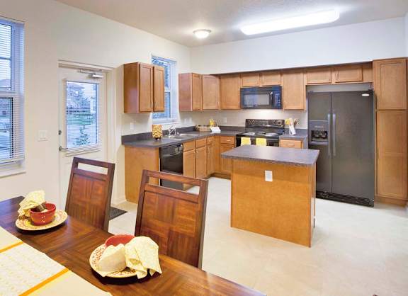 A kitchen with a table set for a meal.